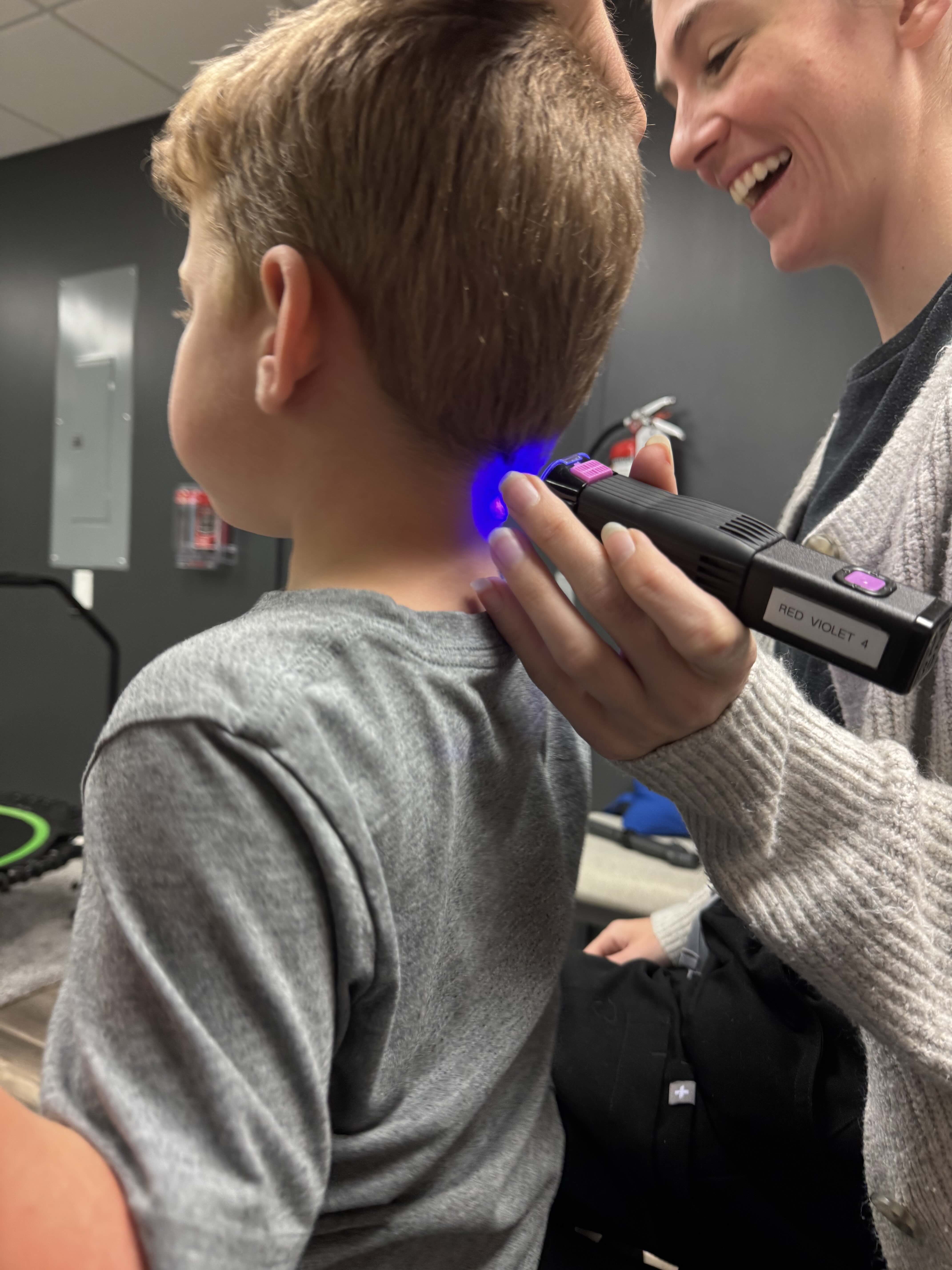 Clinician providing laser therapy treatment to patient